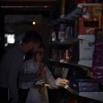 Varios clientes se iluminan con el móvil en un supermercado del centro de Barcelona durante el corte de suministro eléctrico que afecta este lunes a España y que ha dejado sin servicio el metro y el tranvia de Barcelona y todas las líneas de ferrocarril en Barcelona, y sin red de teléfonos móviles ni internet.