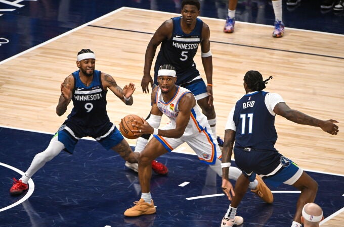Tres jugadores de los Wolves intentan frenar a Shai Gilgeous-Alexander